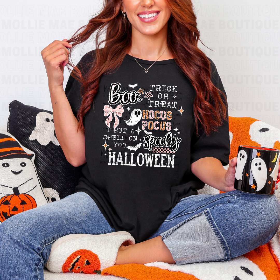 Woman wearing Spooky Quotes Graphic Tee on black Gildan Softstyle, sitting with Halloween-themed decor.