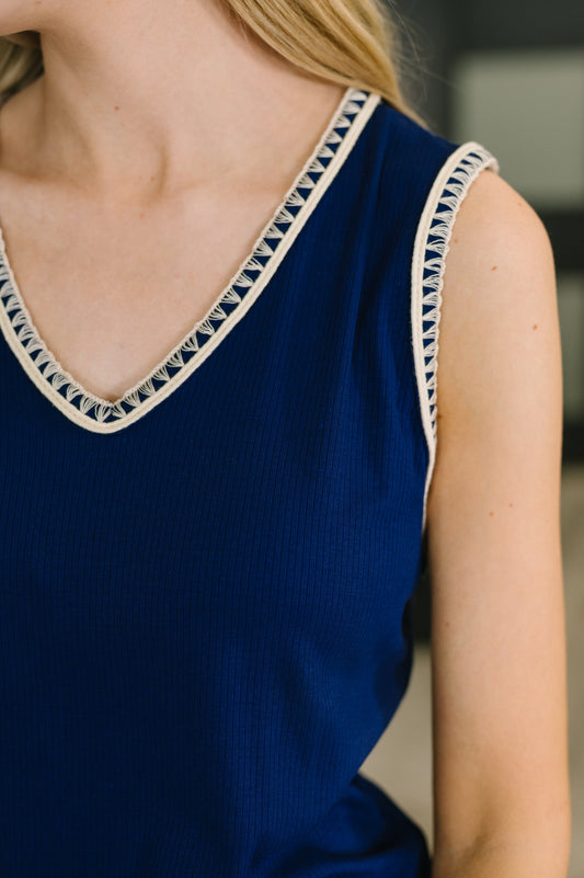 Navy blue sleeveless top with decorative trim on neckline