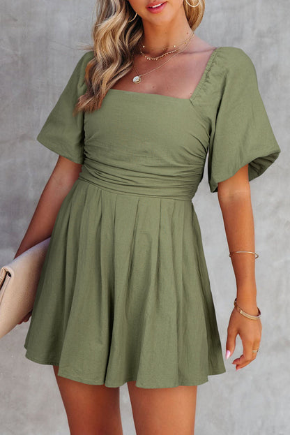 Woman wearing a green dress against a gray background