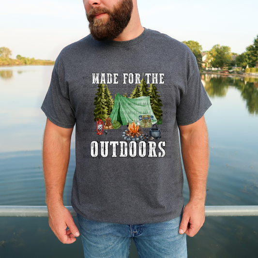 Man wearing Made For The Outdoors graphic t-shirt featuring a tent, campfire, and trees, printed on a Gildan Heather Graphite shirt.