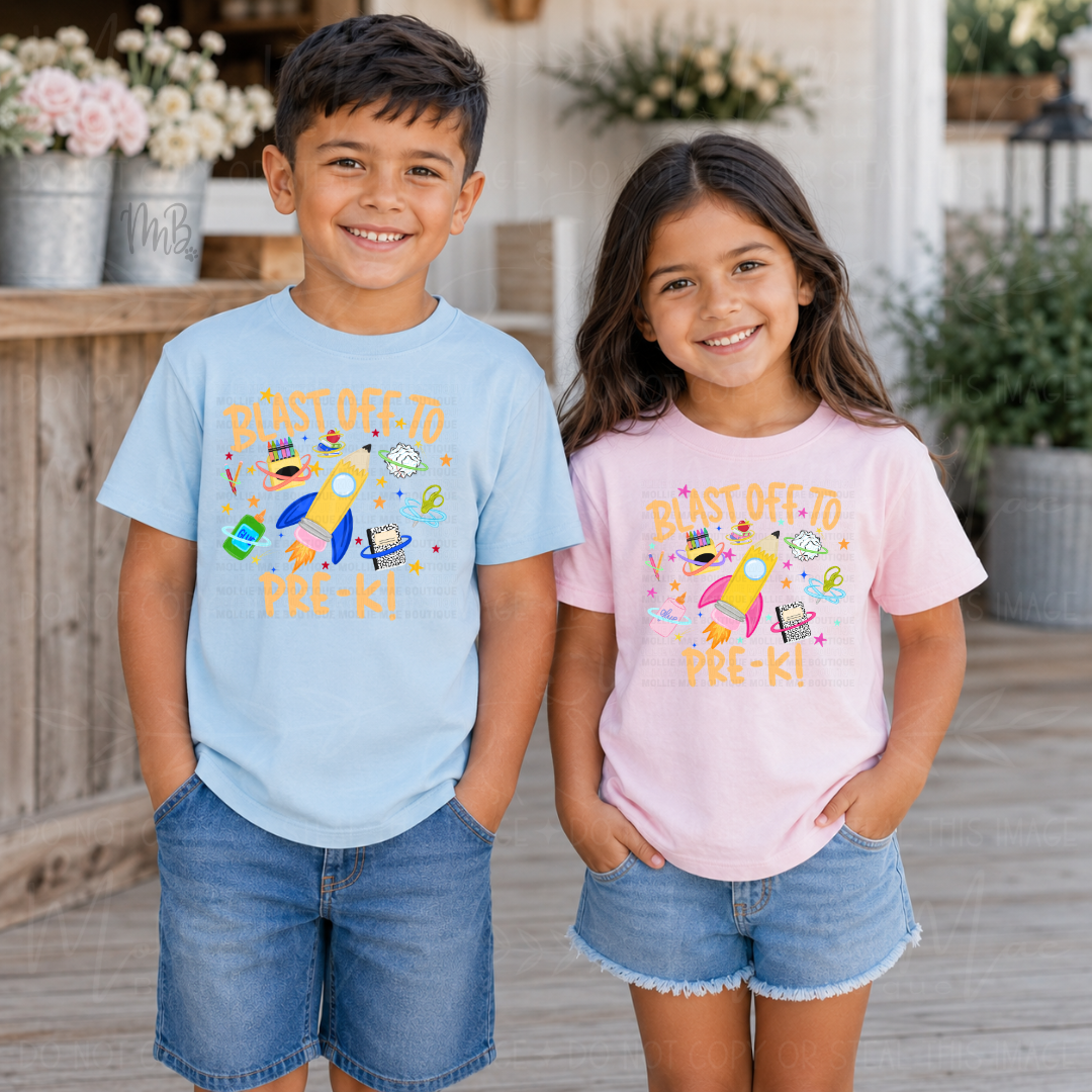 A boy and a girl standing side by side wearing matching light blue and light pink graphic t-shirts with a colorful rocket design and the text 'BASTED OFF PRE-KI'.