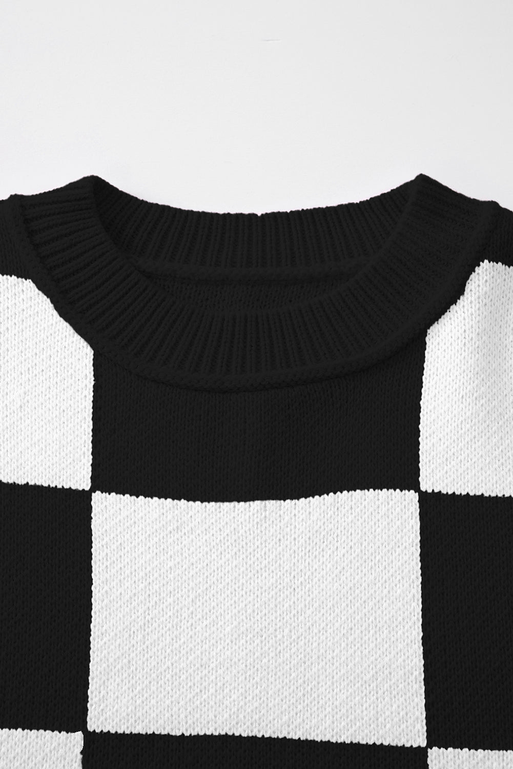 Black checkered exposed seam drop shoulder sweater with checkered knit, exposed seam details and relaxed drop shoulders, women’s boutique fashion