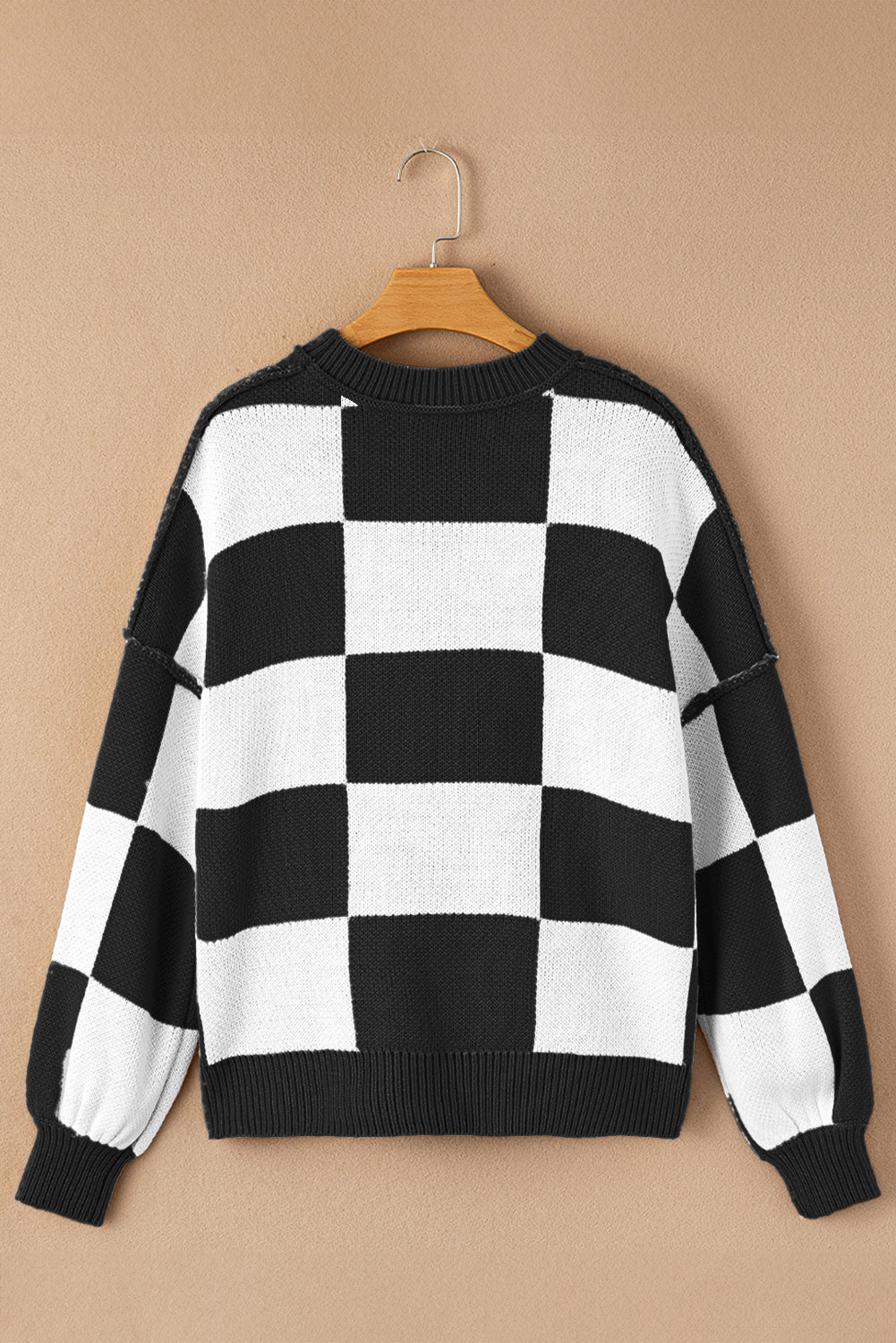 Black checkered exposed seam drop shoulder sweater with checkered knit, exposed seam details and relaxed drop shoulders, women’s boutique fashion