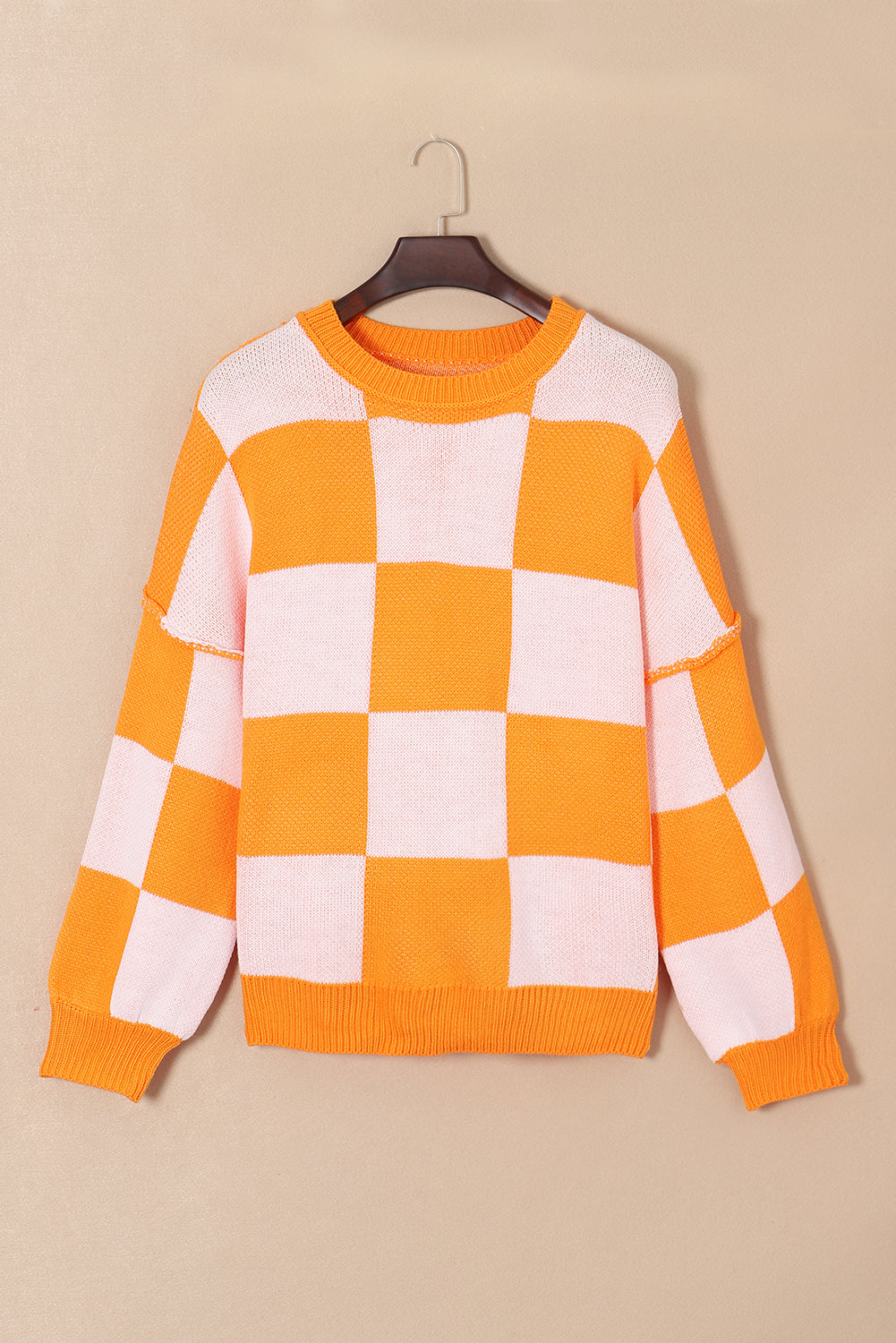 Grapefruit Orange checkered exposed seam drop shoulder sweater with checkered knit, exposed seam details and relaxed drop shoulders, women’s boutique fashion