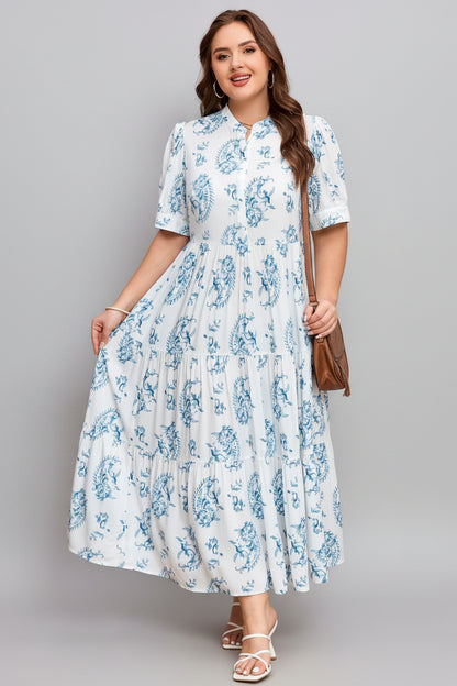 Woman wearing a white dress with blue floral patterns against a pink polka dot background