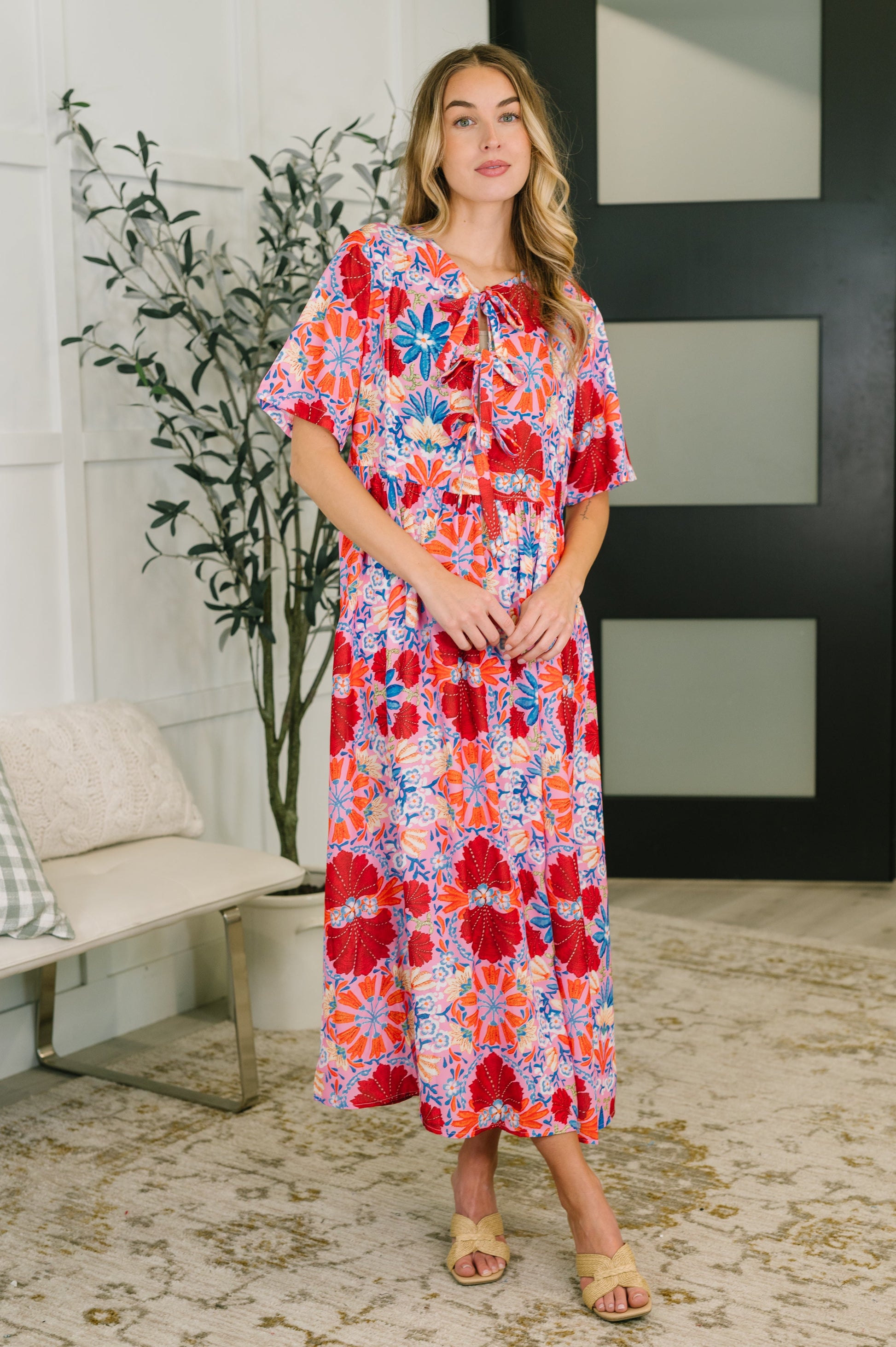 Woman wearing a colorful floral dress in a home setting