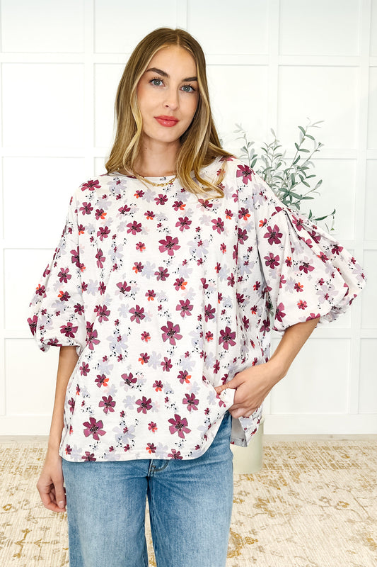 Woman wearing a floral blouse with a white tiled wall background