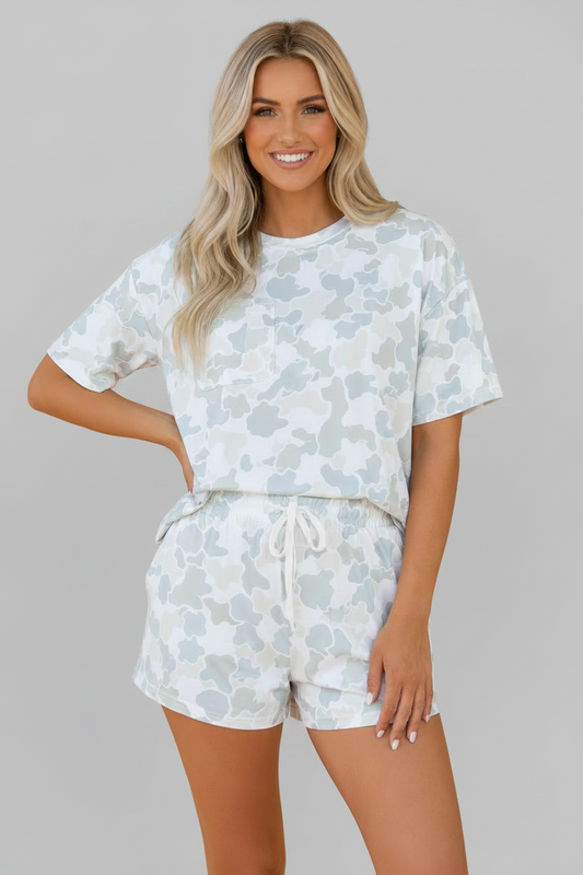 Woman wearing a light blue floral pajama set on an orange background