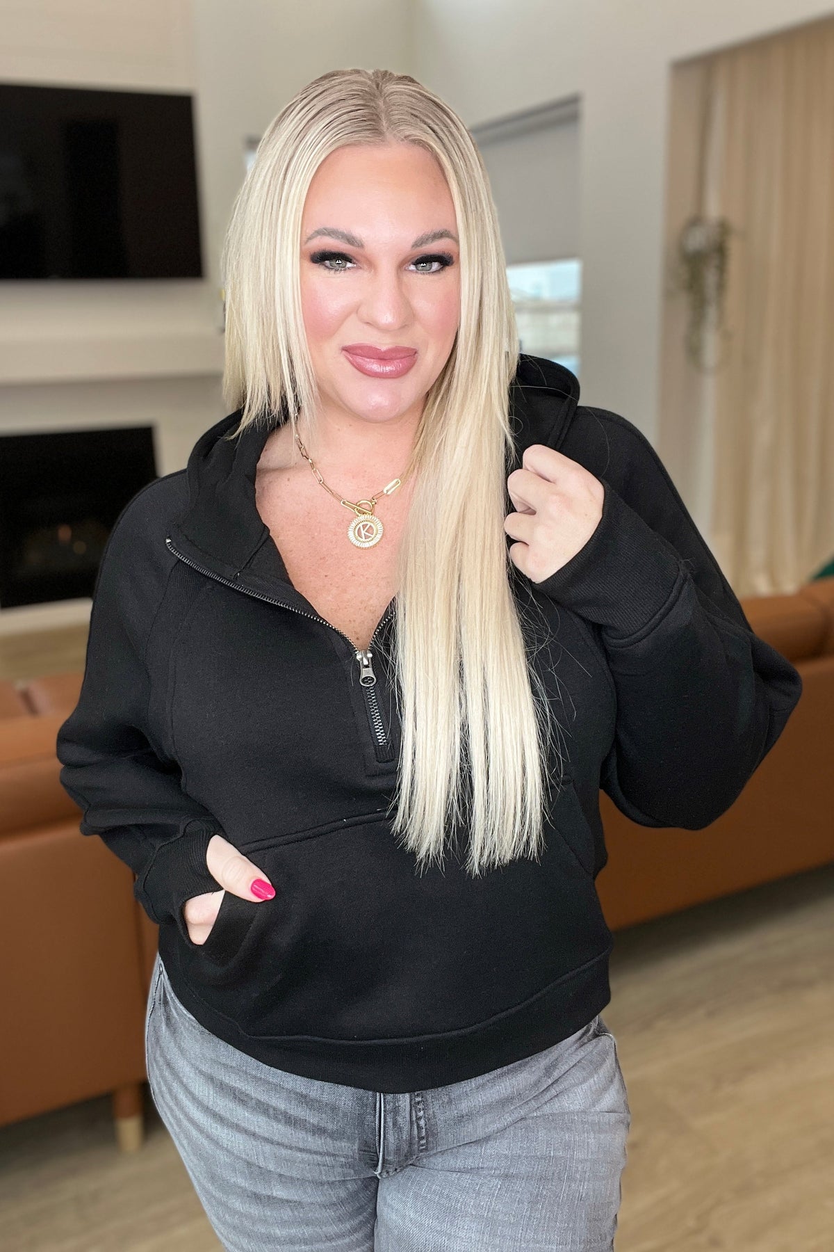 Woman wearing a black jacket in a living room setting