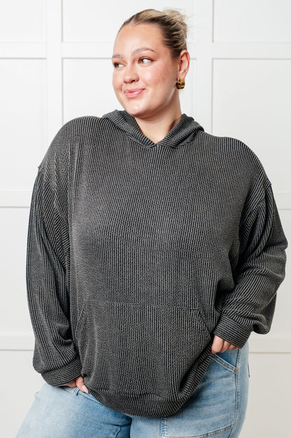 Woman wearing a gray oversized hoodie against a white background