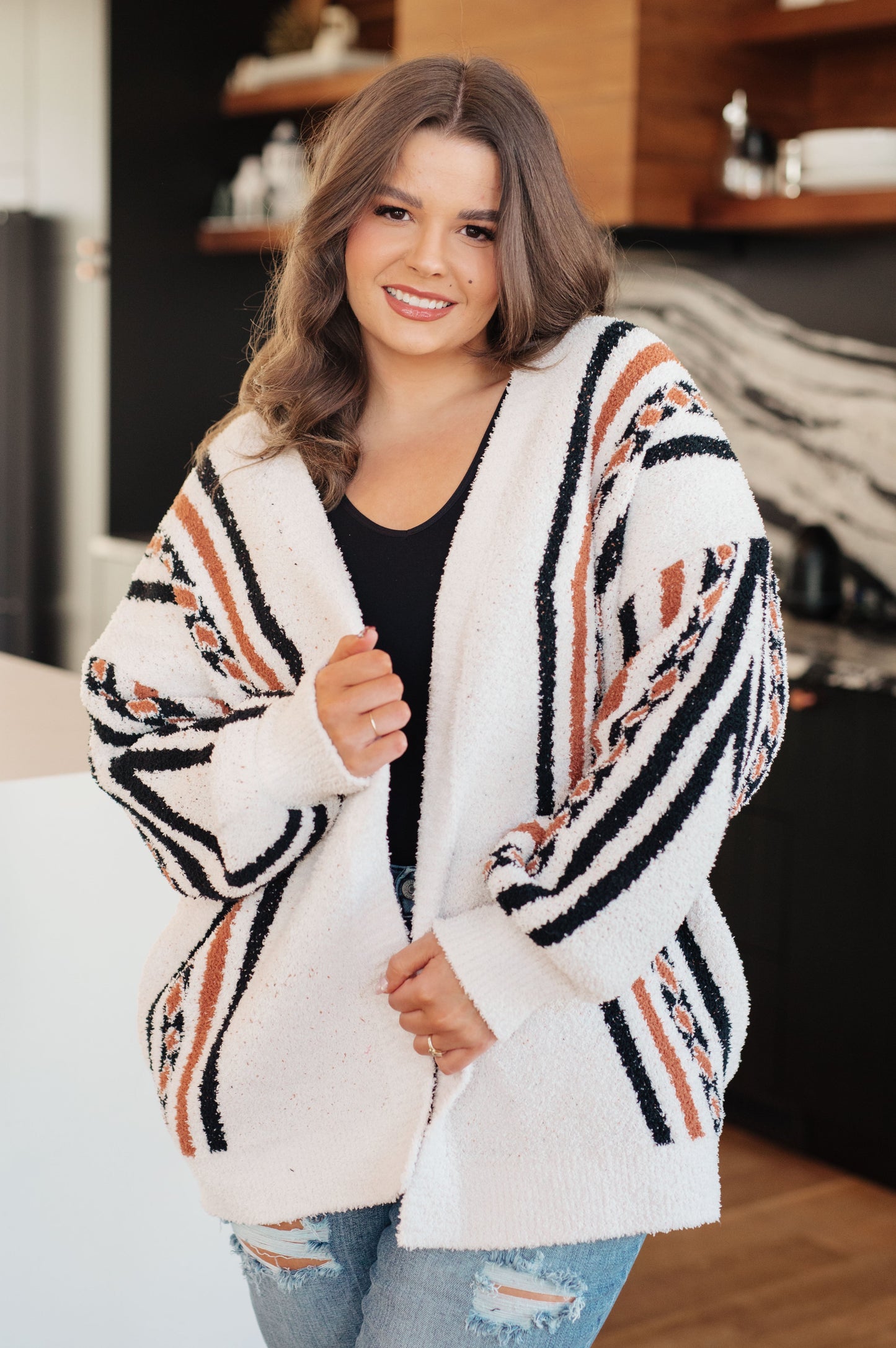 Woman wearing a patterned cardigan in a casual indoor setting