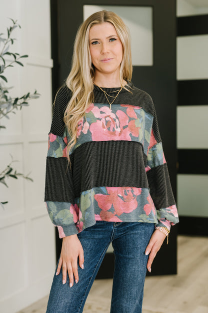 Woman wearing a floral sweater and jeans indoors