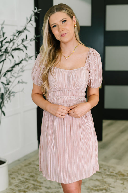 Woman wearing a light pink dress with a blurred background