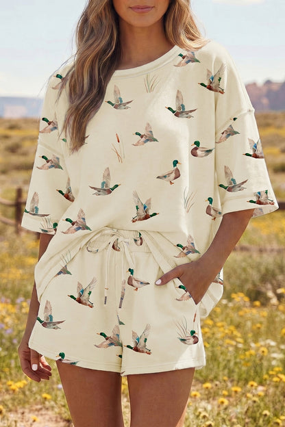 Woman wearing a cream-colored outfit with duck print in a field