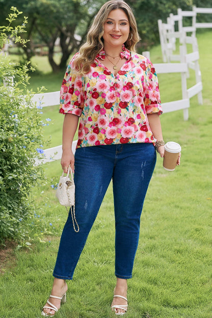 Woman in a colorful floral shirt and blue jeans standing outdoors holding a coffee cup.