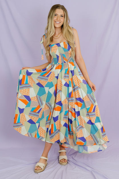 Woman wearing a colorful geometric patterned dress indoors.