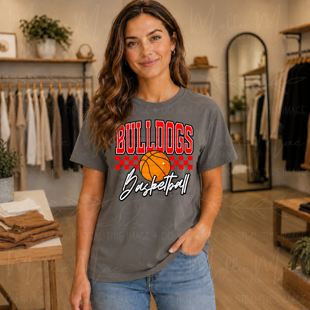 Pepper Comfort Colors Bulldogs Basketball graphic tee featuring bold red team lettering, basketball graphic, and checkered game day design.