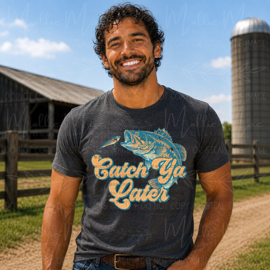Dark Heather Gildan Softstyle graphic tee featuring a retro bass fishing design with Catch Ya Later lettering and vintage outdoor styling.