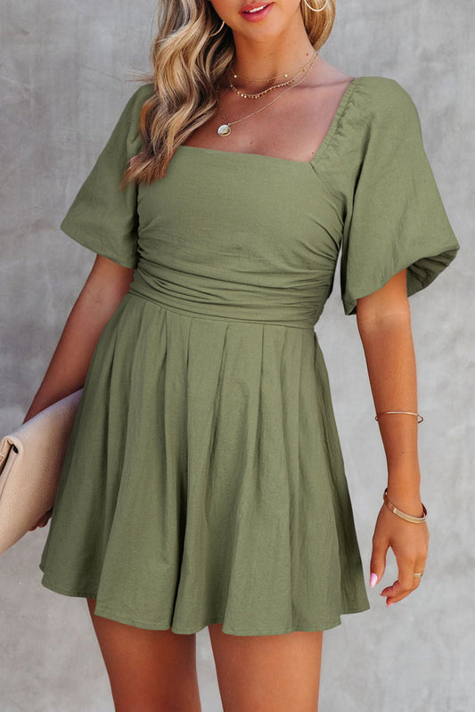 Woman wearing a green dress against a gray background