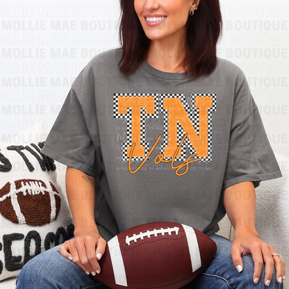 Woman wearing TN Vols Checkered Graphic Tee in charcoal holding football
