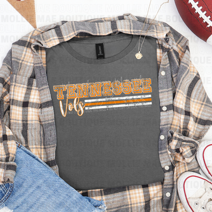 Flatlay Tennessee Vols Stripe Graphic Tee in charcoal styled with flannel and sneakers.