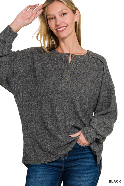 Lady wearing a grey button up Hacci sweater.